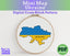 Cross-stitch pattern of Ukraine's flag in an embroidery hoop on a white background